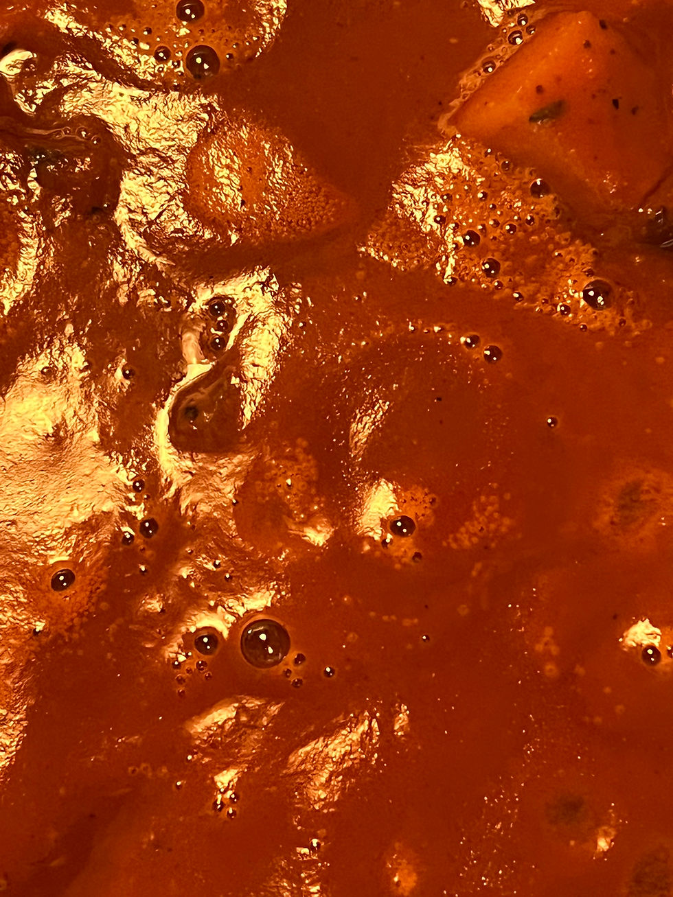 Close-up of domoda’s thick peanut gravy, dense and slow-moving, holding time, labor, and layered flavor in its surface.
