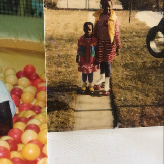 Vintage outdoor photograph of two young Black siblings standing together on a sidewalk wearing roller skates in front of a backyard.