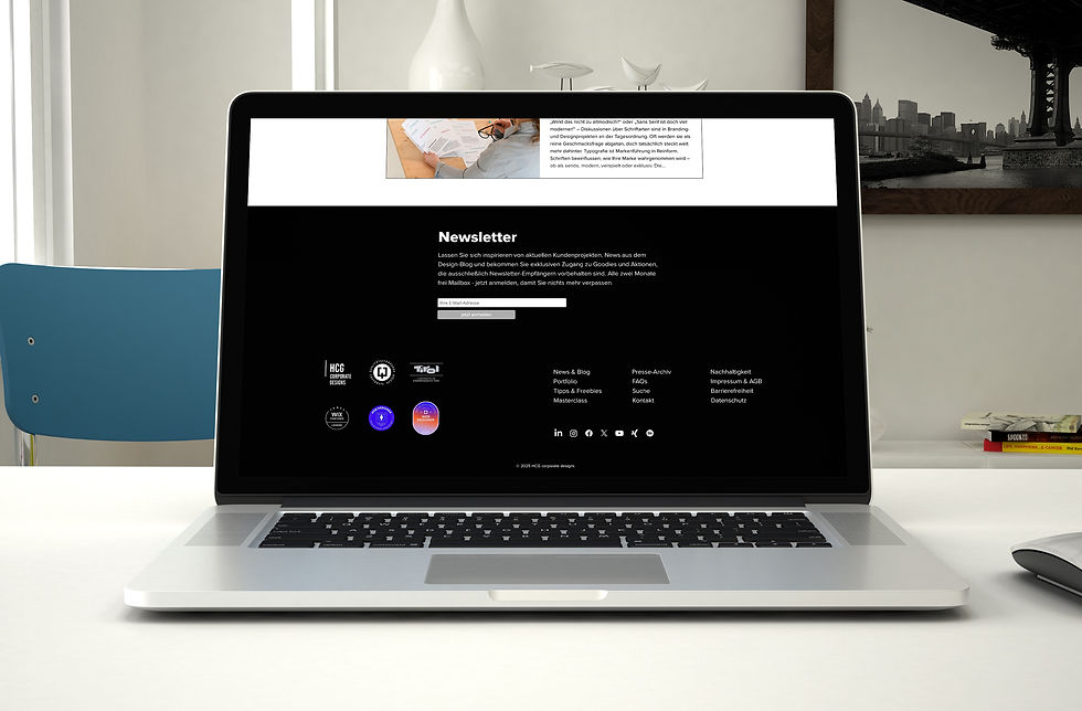 Laptop on a white table with an open newsletter form against a black background. Blue chairs, books, and a black and white image in the background.