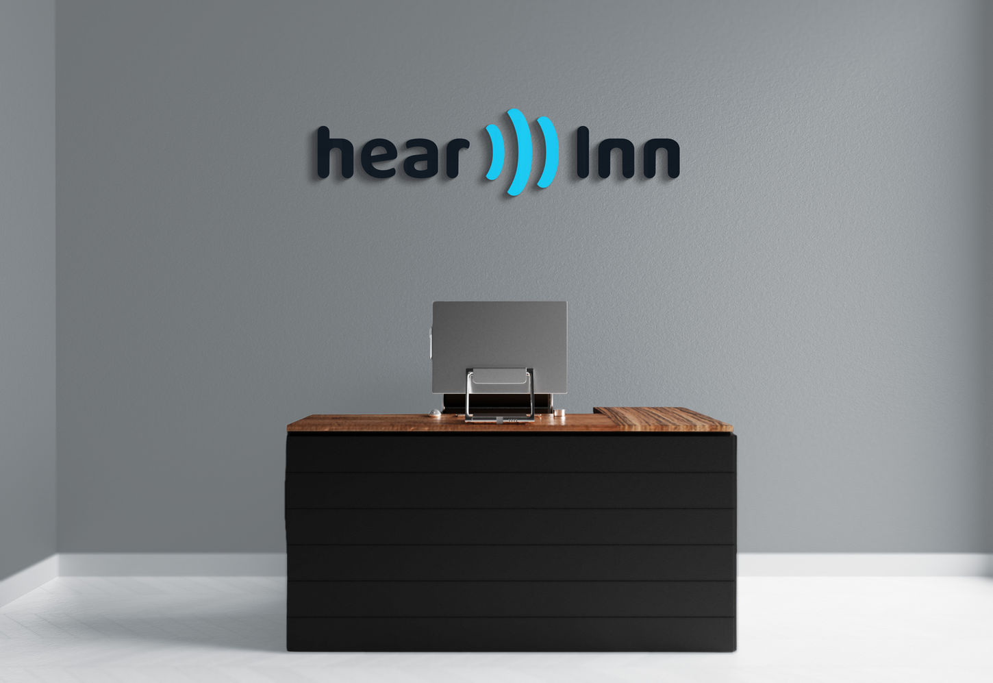 hearInn Logoschriftzug an der Wand über einem Schreibtisch