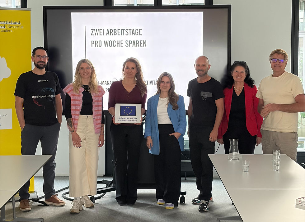 Gruppe von sieben Personen im Konferenzraum vor einer Leinwand mit Zwei Arbeitstage pro Woche sparen und EU-Kofinanzierung.