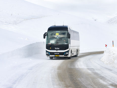 Reisebus MAN Lion's Coach E im Winter unterwegs auf Landstraße.