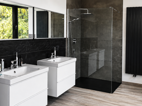 Kompleksowe wykończenie nowoczesnej łazienki premium wykonane przez R.S.C Renovation Service Company – prysznic walk-in, podwójna umywalka, wanna z hydromasażem, płytki wielkoformatowe oraz nowoczesne wykończenie wnętrza.