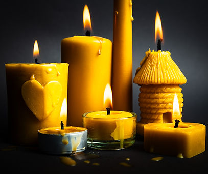 świece z naturalnego wosku pszczelego zapalone: świeczka o kształcie walca z motywem serca, świeczka o kształcie walca, świeczka prosta, świeczka o kształcie ula, świeczka tealight w aluminium, świeczka tealight w szkle, świeczka o kształcie serca, na czarnym tle