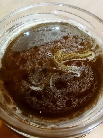 piankę na powierzchni miodu w szklanym słoiku