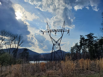 Silhouette of electrical wires with mountains and a lake in the background