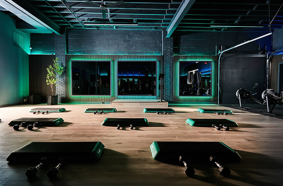 Groove Theory Fitness in Maplewood nj vibrant fitness space with dark walls and color changing lights with halo effect around mirrors