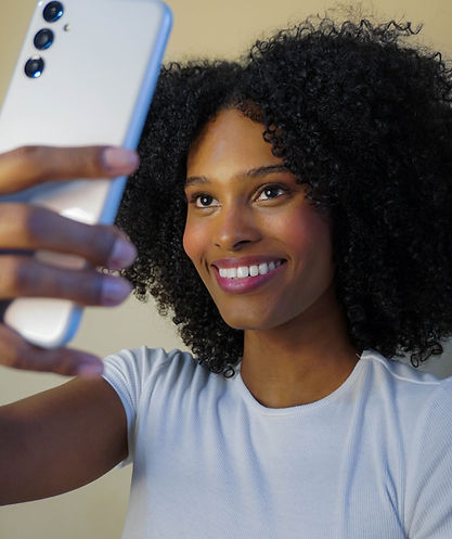 "Modelo Geovana Ribeiro tirando uma selfie com um sorriso confiante, mostrando um estilo moderno e autêntico."