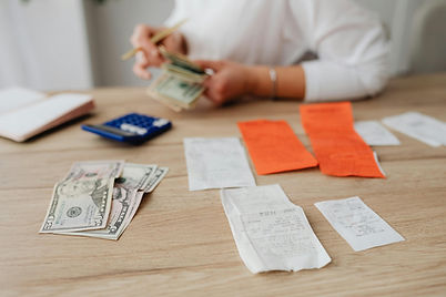 Plan sur une séance de comptabilité montrant des reçus, des dollars américains et une calculatrice pour illustrer la gestion des dépenses.