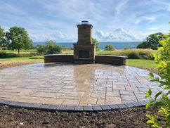 Outdoor stone fireplace on round paver patio

