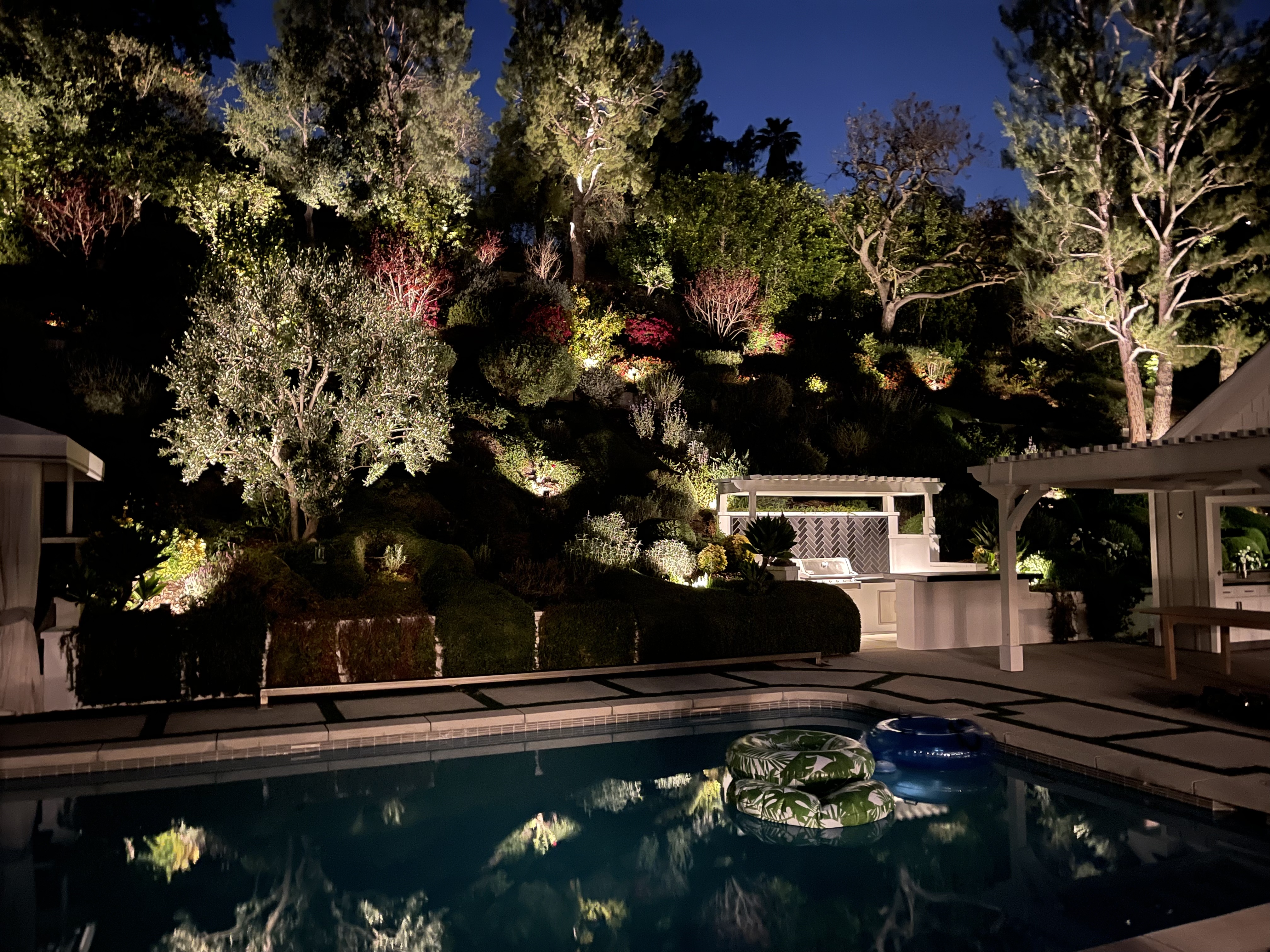 Outdoor living landscape featuring multiple illuminated areas