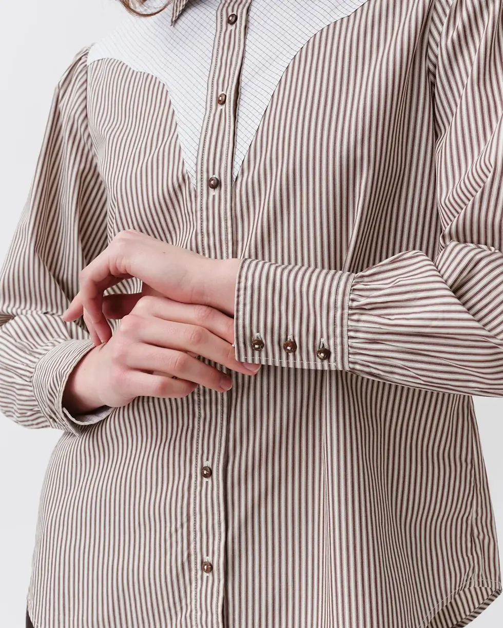 Miniature : Chemise Costelina Diega détail de la manche, le modèle ajustant délicatement son poignet pour révéler les finitions et les dé