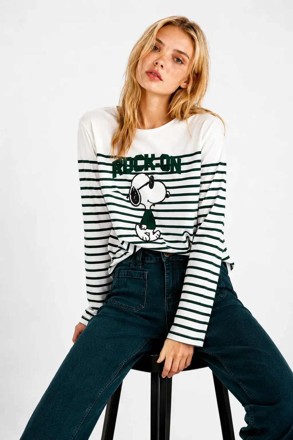 Tee-shirt Snoopy Rock On Five Off White porté par un modèle assis sur une chaise, de face