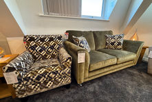 Green velvet sofa and patterned armchair in a showroom