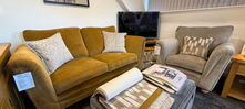 Alstons Gold Two Seater, armchair, and fabric samples in a showroom.