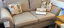 Small beige two-seater sofa with patterned cushions.