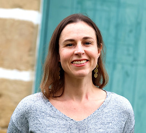 A smiling headshot of Julia Cope, freelance medical writer, on a turquoise background.