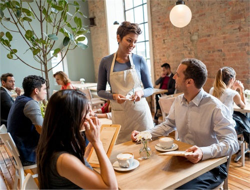 Waitress taking order from couple in cafe
