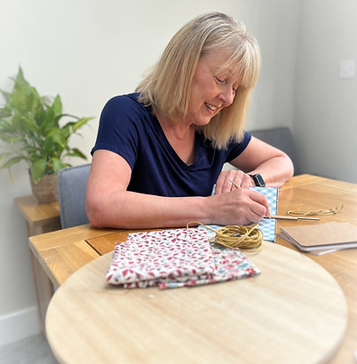 Sewing a handmade book signature using traditional bookbinding methods at a work desk