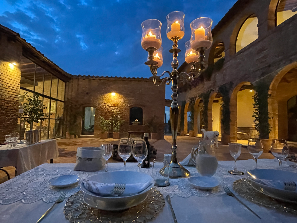 Private dining experience in the Tuscan countryside at Podere delle Querce, elegant table set in nature.