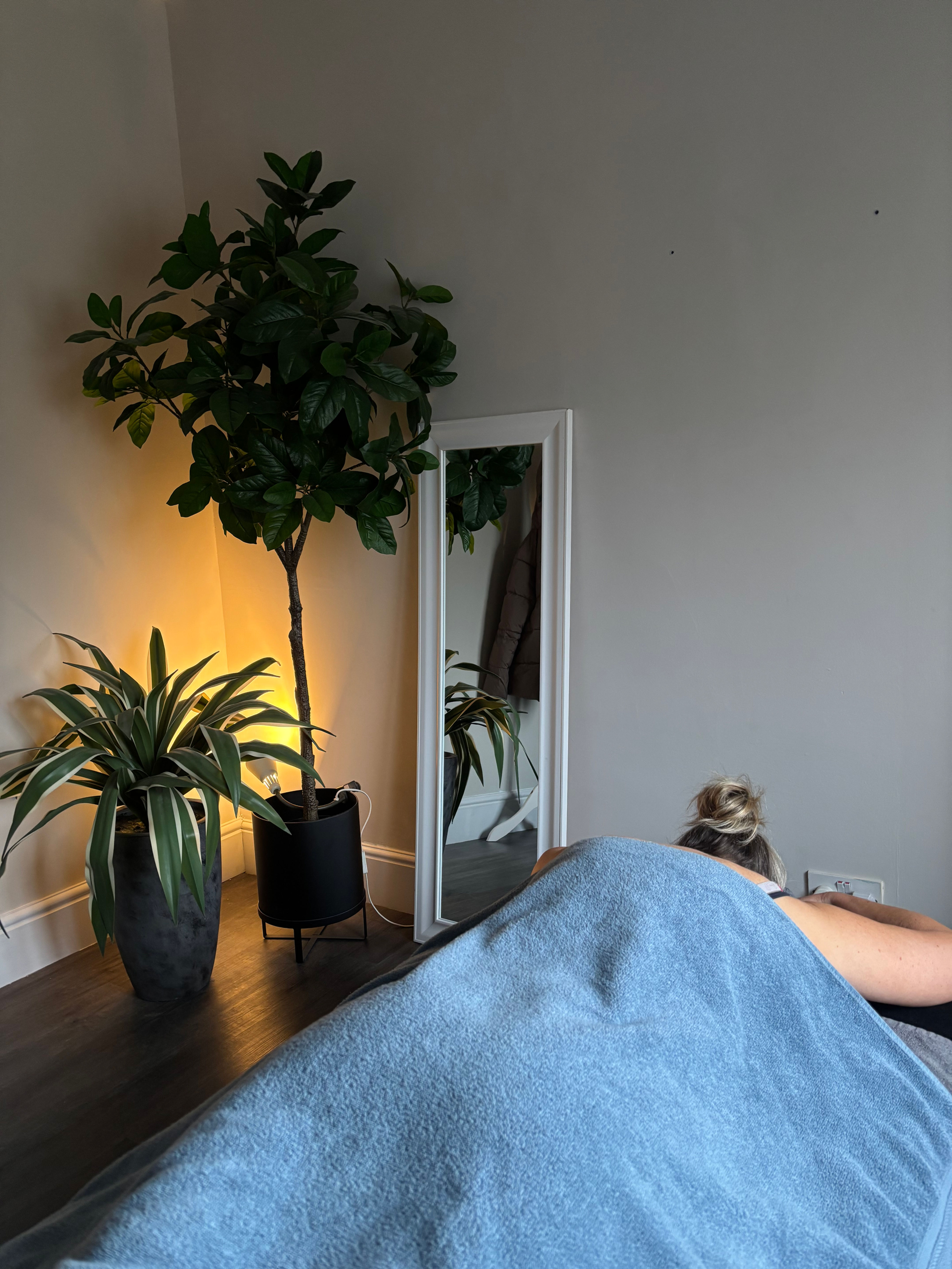 Sports massage in Macclesfield being performed in a calming, mood-lit treatment space