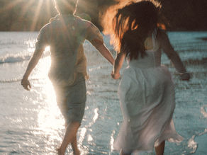 Couple running on a beach at sunset