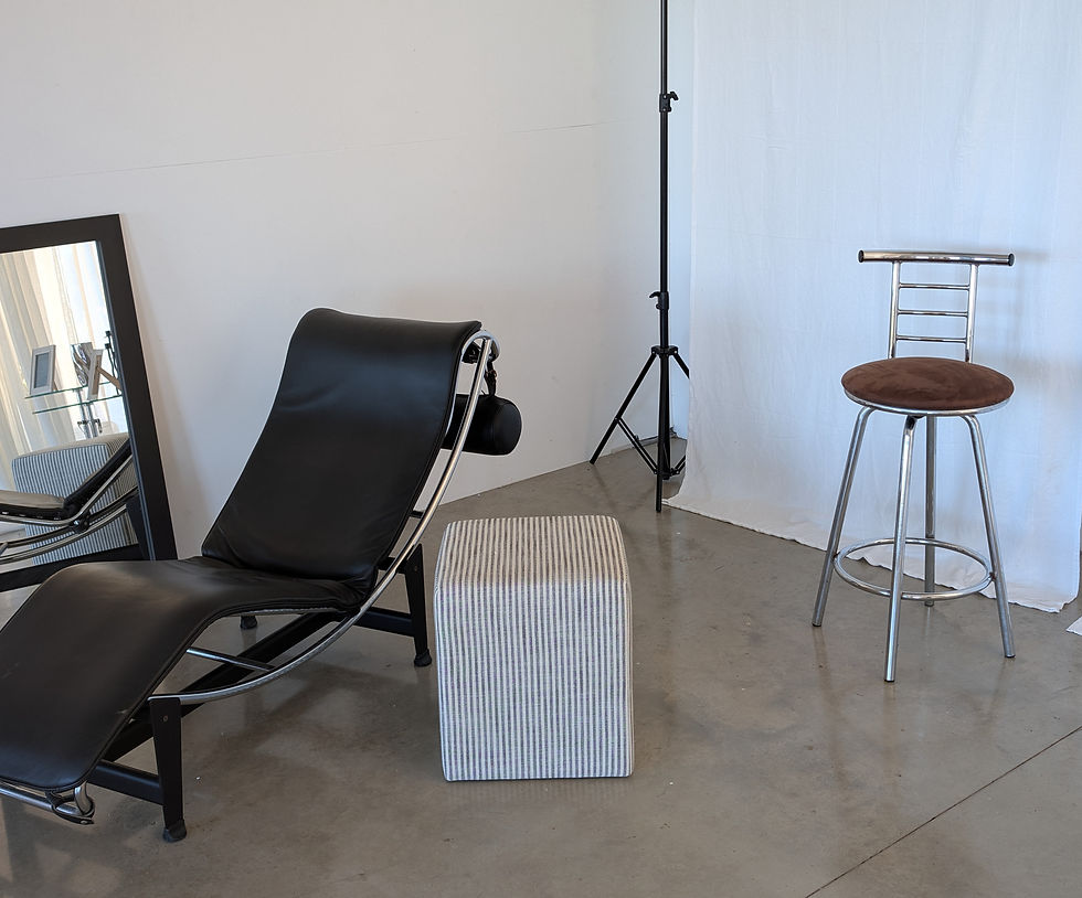 Photography studio with black leather lounge chair, light stand and backdrop at Fields Creative