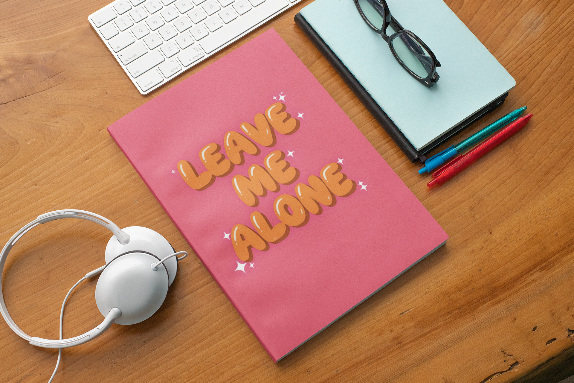 Leave Me Alone funny introvert notebook on desk with pink cover