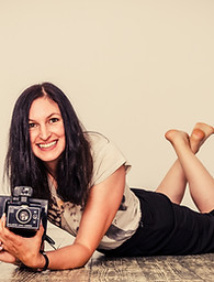 Lächelnde Fotografin mit Vintage-Kamera