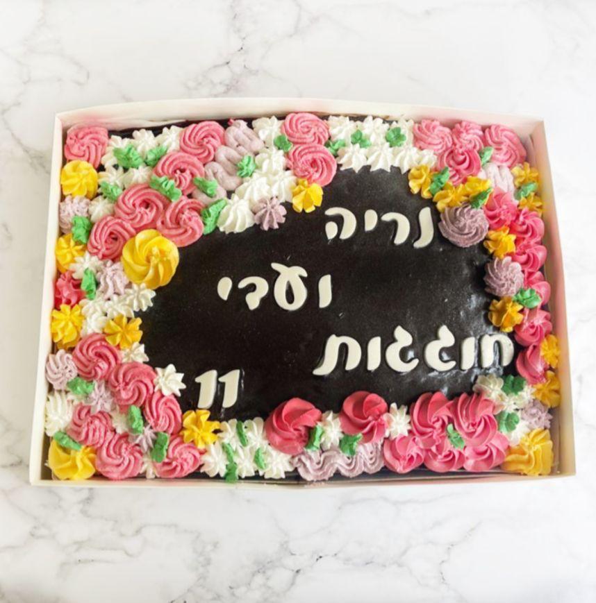 עוגת שוקולד מלבנית עם כיתוב ומסגרת פרחים צבעונית
