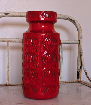 Close-up view of vibrant red vintage West German pottery
