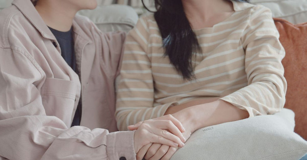 Two people sitting on a couch holding hands