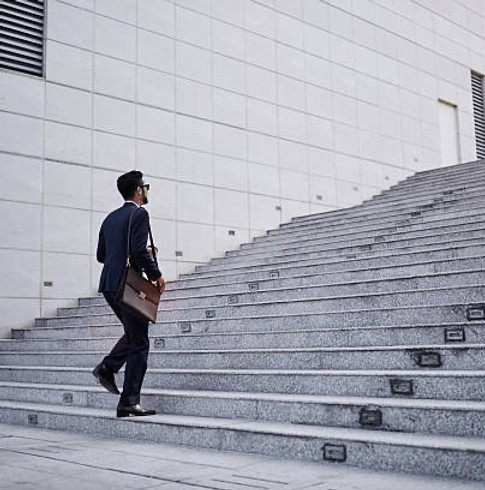 Professional walking up steps, representing forward planning and progress.