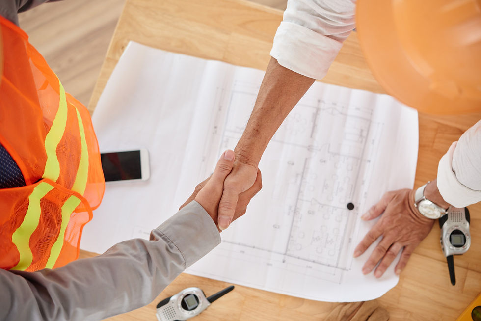 Handshake over construction blueprint symbolizing collaboration and agreement in custom home building project