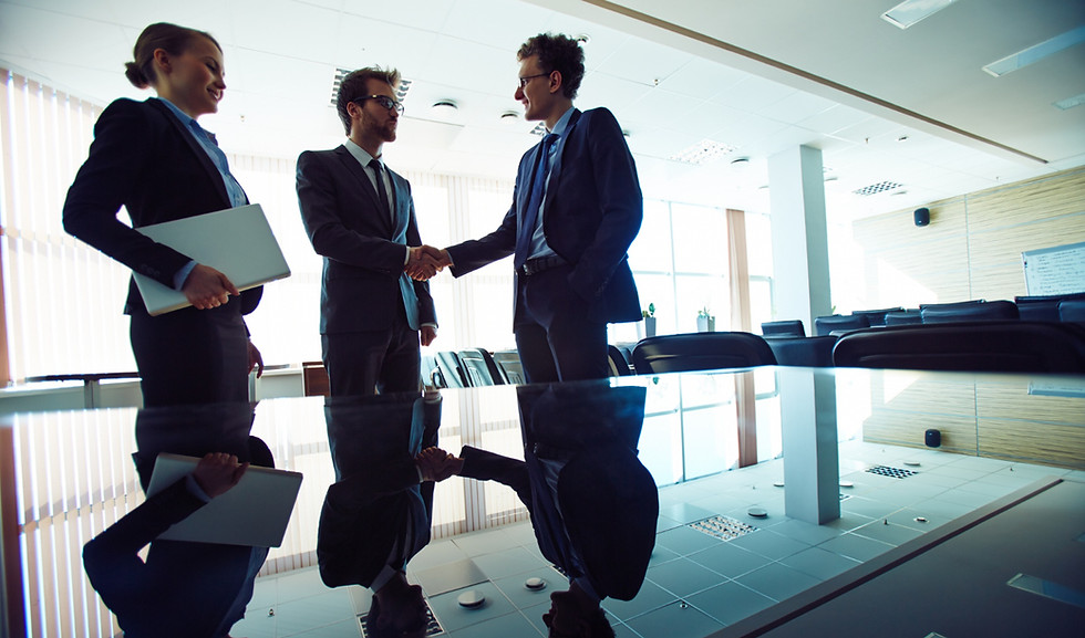 Business professionals shaking hands during a hotel business development meeting.