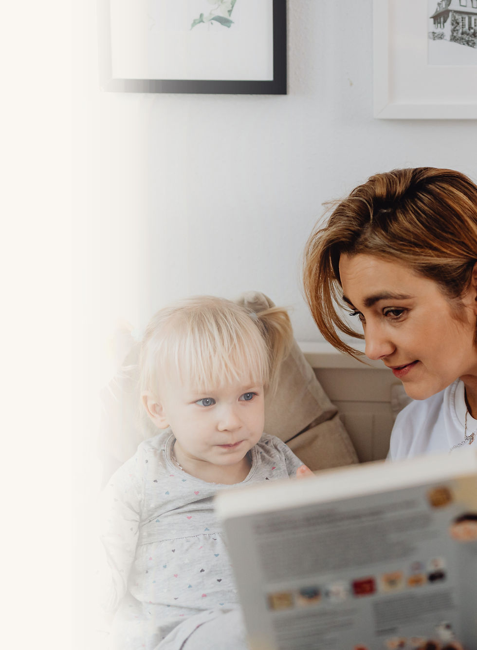 Nanny reading a storybook to a little girl.