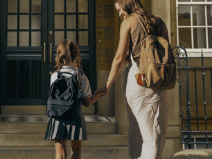 Mother and daughter walking up to the doors of a British School.