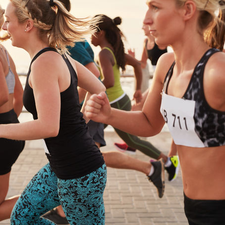 Group of women running a race near body of water