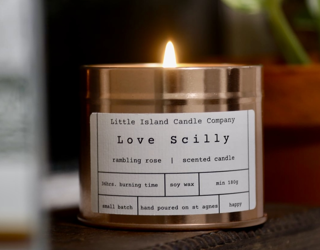 Love Scilly candle, lit, in a rose gold tin