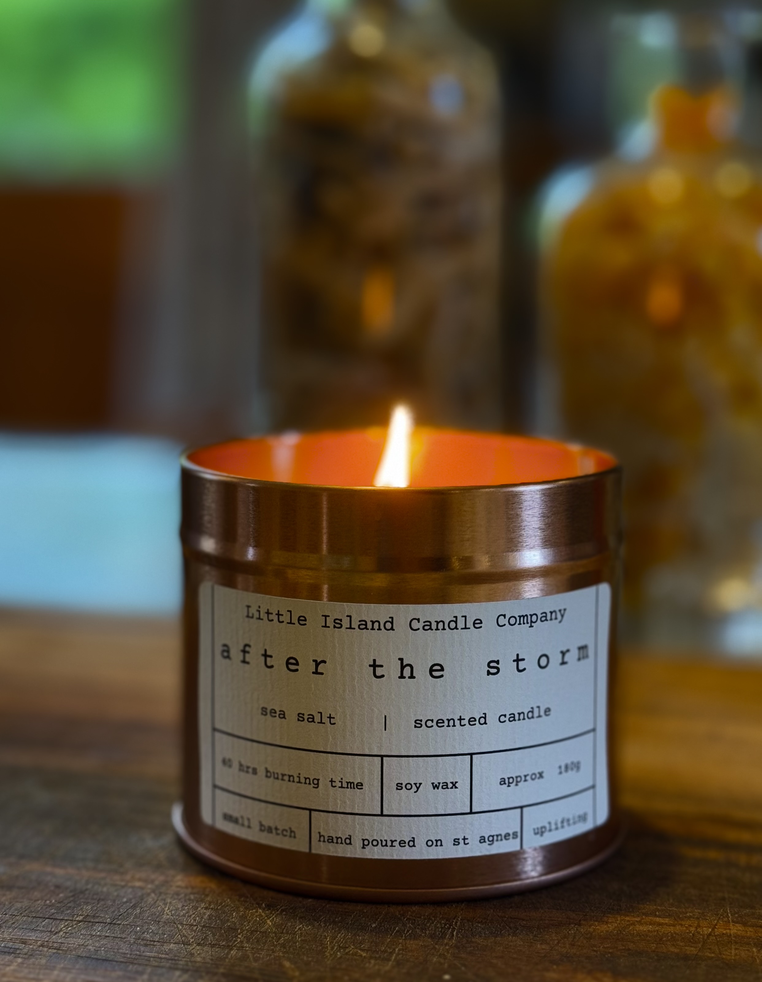 After the Storm candle, lit, in a rose gold tin