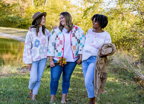 A group of three women wearing quilt jackets.