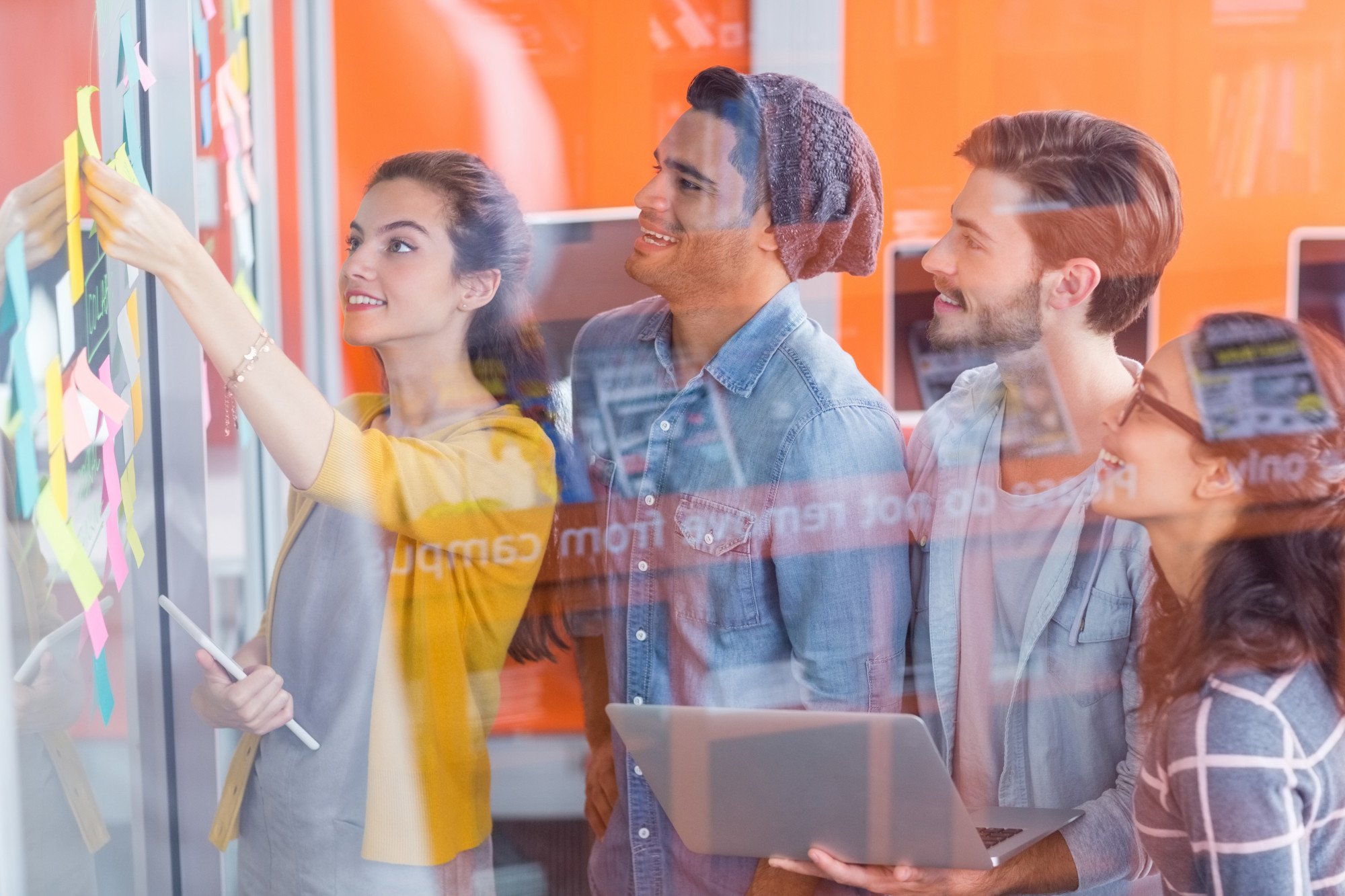 smiling-executives-discussing-sticky-notes-glass-wall_107420-61290.jpg