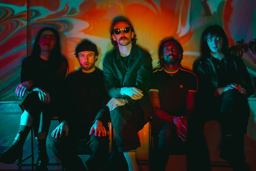 Five people (pôt-pot) sit against a vibrant, psychedelic swirl background. They display calm expressions. The scene is colorful and moody.