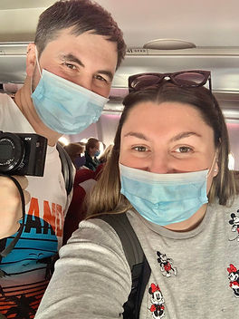 Jessica and Wayne Heather on a plane during the covid pandemic wearing face masks
