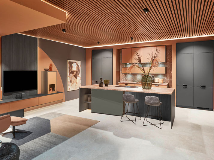 Dark grey kitchen with a central island, warm orange walls and a slatted wood-effect ceiling.