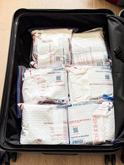 Beer cans inside padded envelopes and ziplock bags inside suitcase for travel