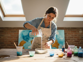 Artist pouring resin in attic workspace