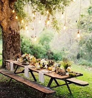 jardín encantador con luces colgadas de un arbol y mesa decorada para la comida de un evento divertido organizado por eBBents se busca un lugar perfecto para cada evento