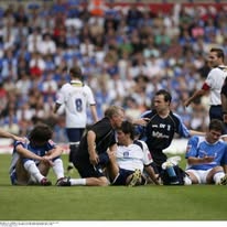 premier league sports physio assessing a on pitch injury
