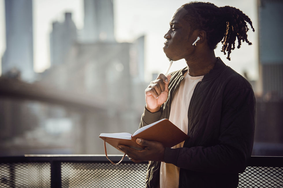 Young African American male with diary and pen thinking hard